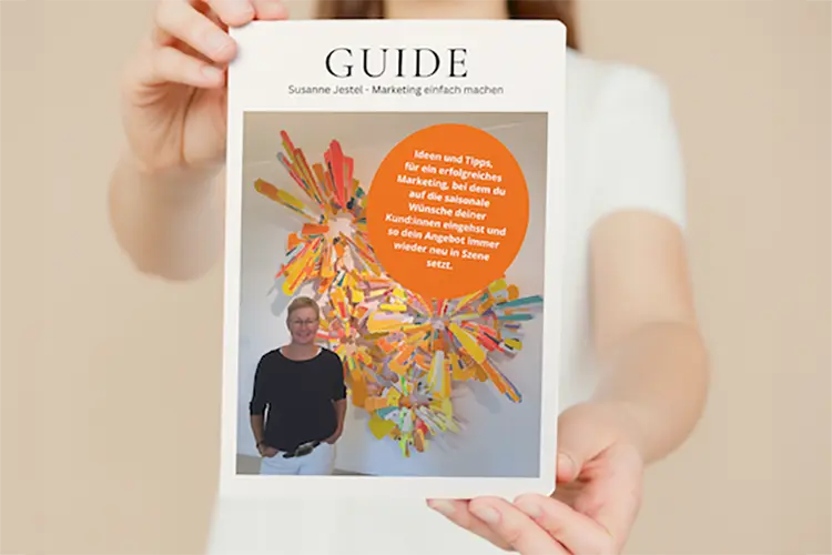 Zwei Hände halten das Cover des Guides "So setzt du dein Angebot immer wieder neu in Szene", das Susanne Jestel unter kostenlosen Ressourcen zur Verfügung stellt.