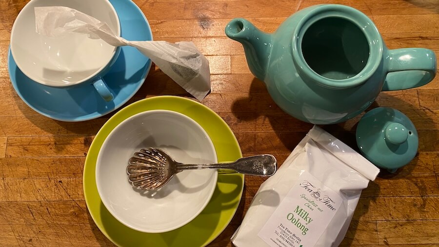 Teetassen und Teekanne mit grünem Tee