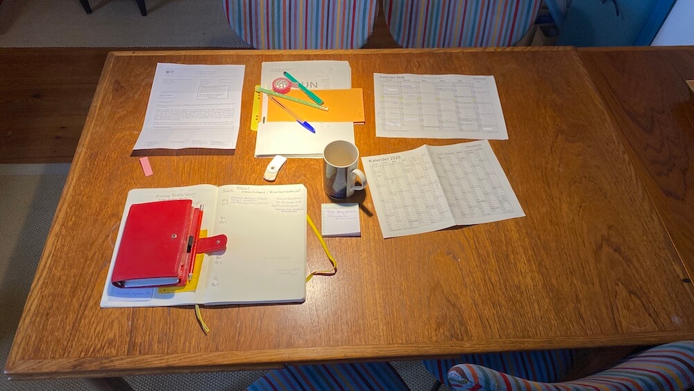 Schreibtisch mit Kalendern und Notizbuch