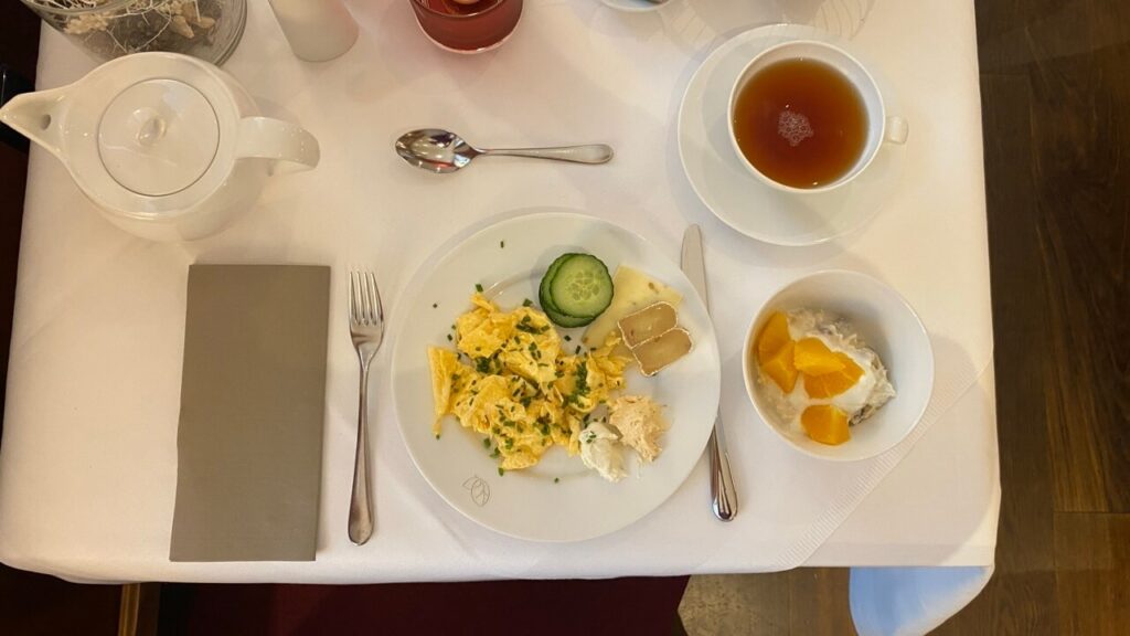 Frühstücksteller mit Rührei, Käsen und Teetasse