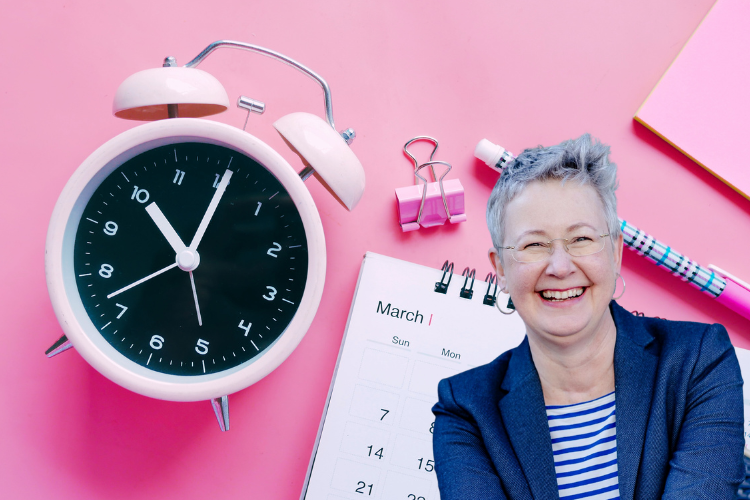 Susanne vor Schreibutensilien und Wecker, der 10:00 Uhr anzeigt.