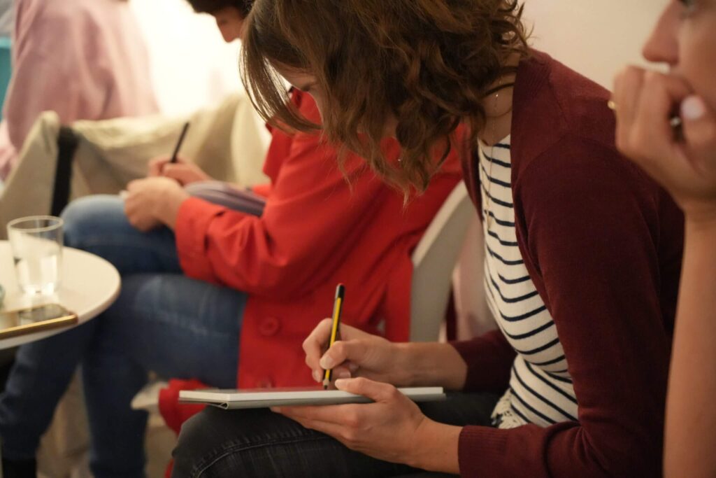 Frauen machen Notizen zu Susannes Vortrag auf dem Netzwerkfrühstück des Projekts Gutplus der LOK.a.Motion GmbH